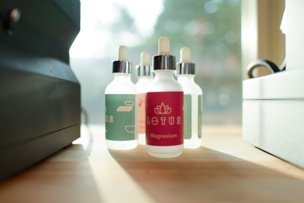 Bottles of Lotus water dropper bottles on a wood table